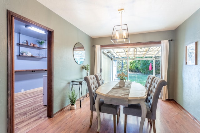 dining area with an inviting chandelier and light hardwood / wood-style flooring