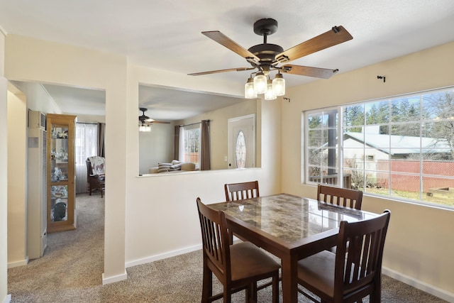 dining space with baseboards, carpet floors, and a ceiling fan