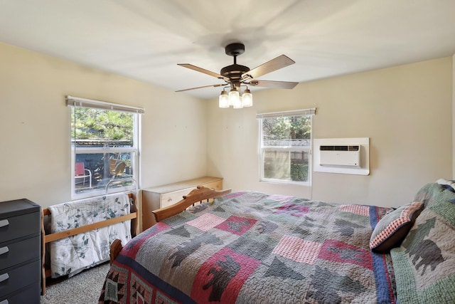 bedroom with a wall mounted air conditioner, ceiling fan, and carpet flooring