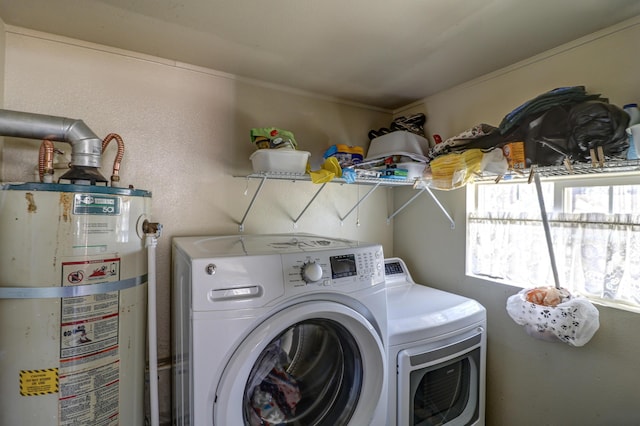 washroom with gas water heater, laundry area, and washer and dryer