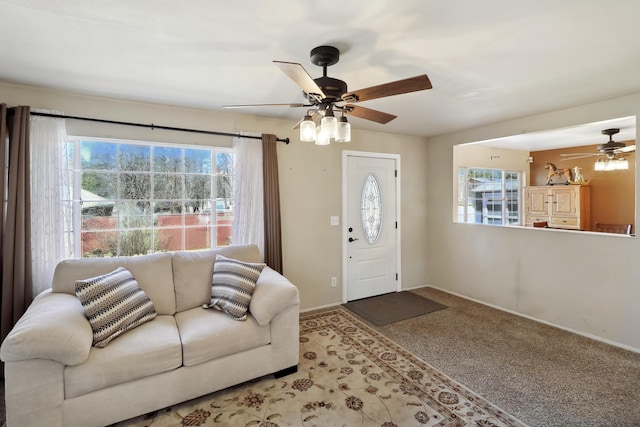 entrance foyer with baseboards, light colored carpet, ceiling fan, and plenty of natural light