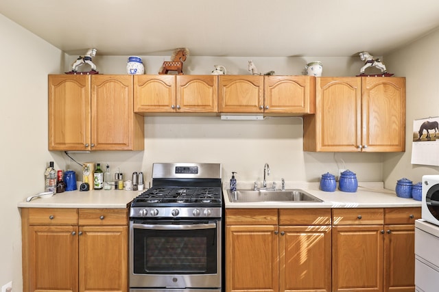 kitchen with light countertops, a sink, and stainless steel range with gas cooktop