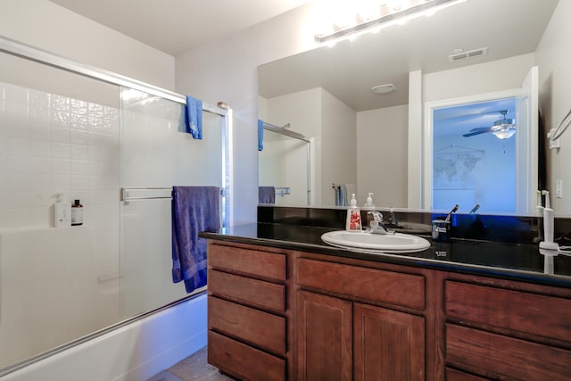 bathroom featuring ceiling fan, vanity, and enclosed tub / shower combo