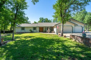 single story home featuring a front yard and a garage