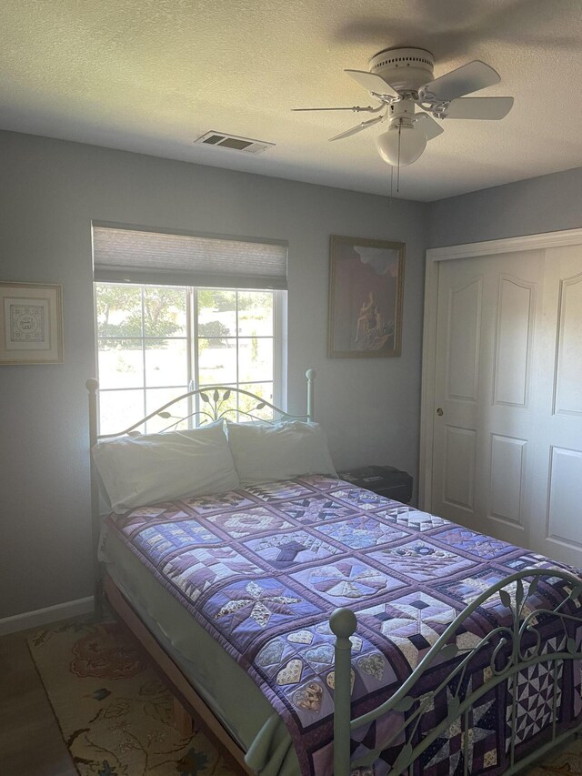 bedroom with a closet, ceiling fan, and a textured ceiling