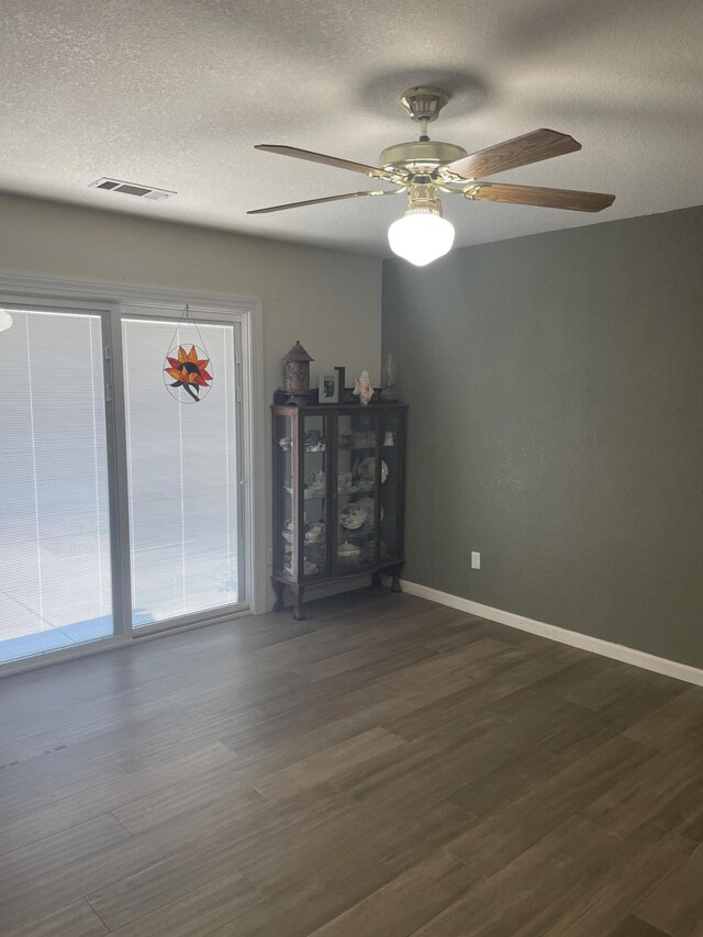 interior space with ceiling fan, dark wood-type flooring, and a textured ceiling