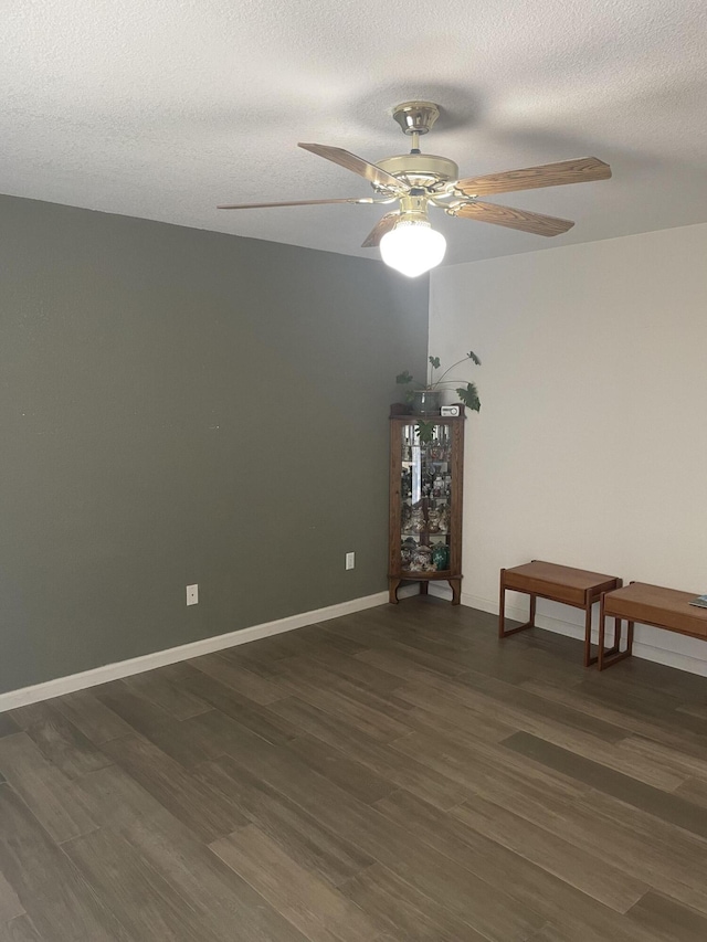 unfurnished room with dark hardwood / wood-style flooring, ceiling fan, and a textured ceiling