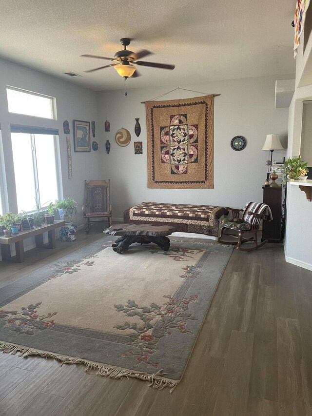 sitting room with ceiling fan, a textured ceiling, and dark hardwood / wood-style flooring