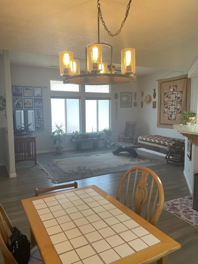 dining room with a textured ceiling and dark hardwood / wood-style flooring