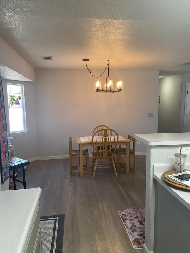 3471 Charles St, Cottonwood, CA 96022 - dining space featuring a notable chandelier, a textured ceiling, dark wood finished floors, baseboards, and visible vents