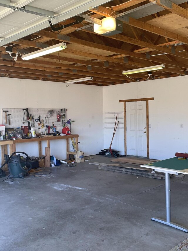 garage with a garage door opener and a workshop area