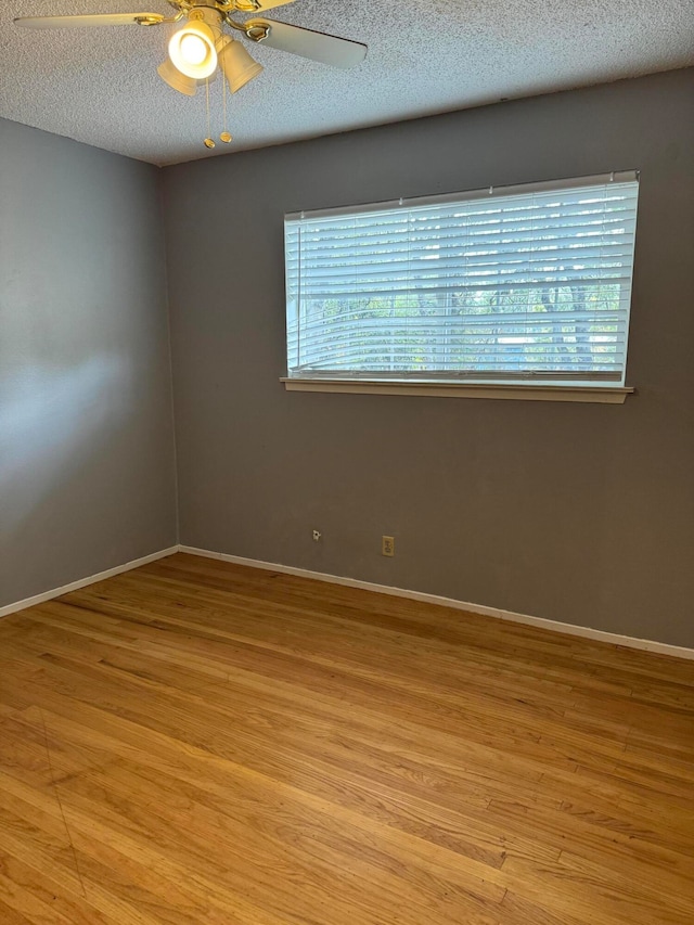 spare room featuring ceiling fan, a textured ceiling, and light wood-type flooring