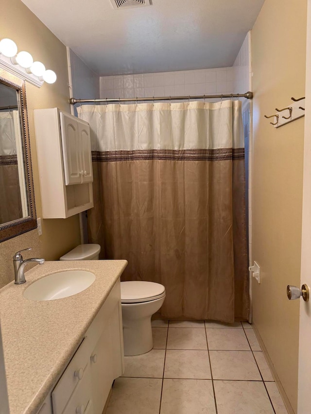 bathroom with toilet, curtained shower, vanity, and tile patterned floors