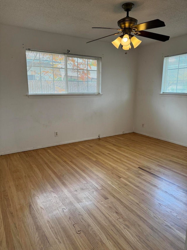 empty room with light wood-type flooring, a textured ceiling, and ceiling fan