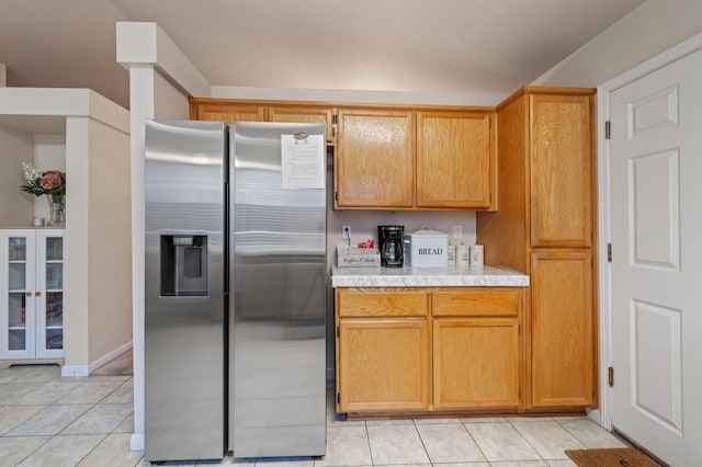 kitchen with stainless steel refrigerator with ice dispenser and light tile patterned floors