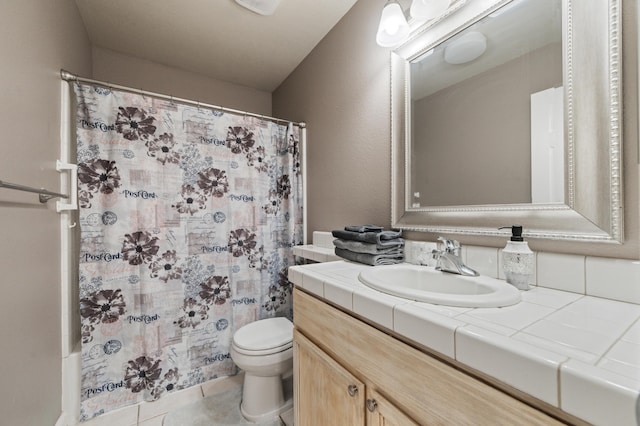 bathroom featuring tile patterned flooring, curtained shower, vanity, and toilet