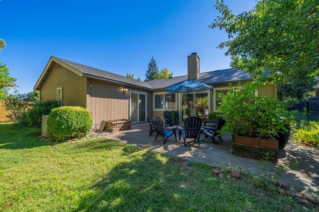 back of house featuring a fire pit, a patio area, and a yard