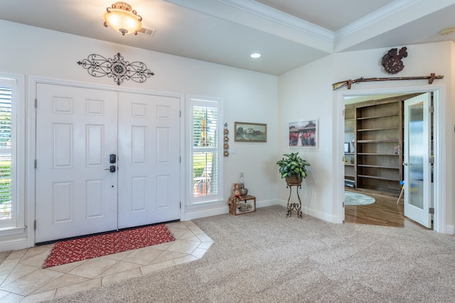 carpeted foyer entrance with crown molding