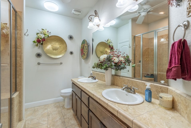 bathroom with tile patterned floors, vanity, toilet, and a shower with door