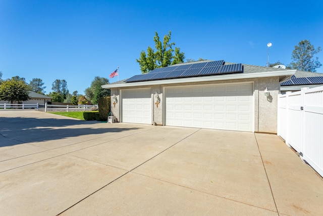 view of side of property with solar panels and a garage