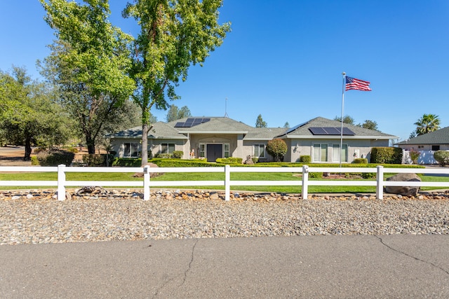 ranch-style house featuring solar panels