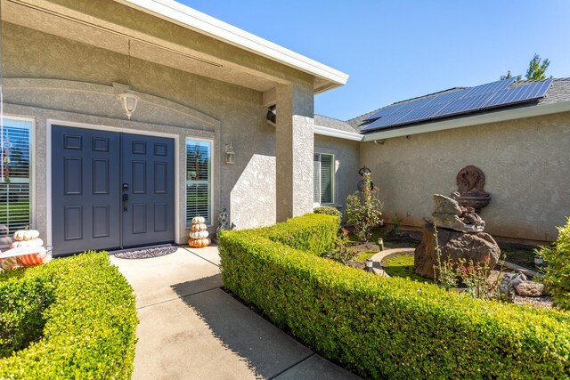 view of exterior entry featuring solar panels