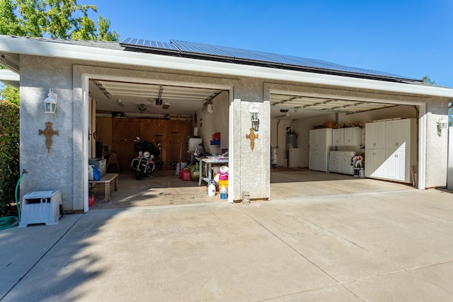 garage featuring solar panels and water heater