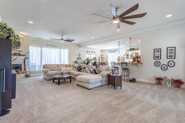 carpeted living room with a tile fireplace, a healthy amount of sunlight, and ceiling fan with notable chandelier