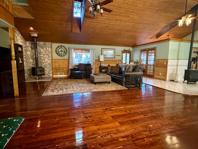 living room featuring ceiling fan, wood-type flooring, wood ceiling, and a wood stove