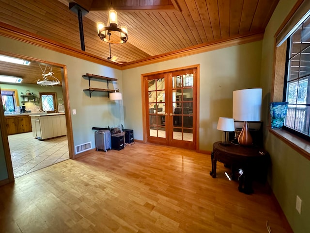 living area featuring light wood-type flooring, a notable chandelier, crown molding, wooden ceiling, and french doors