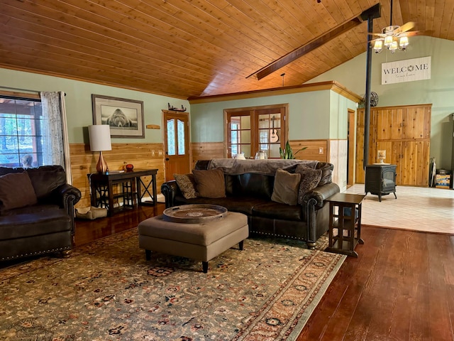 living room featuring ceiling fan, a wood stove, wood-type flooring, lofted ceiling with beams, and wooden ceiling