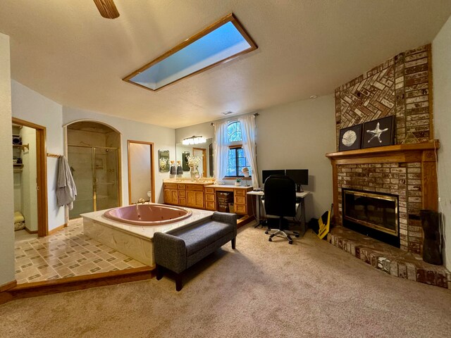 carpeted living room with a brick fireplace, a skylight, and a textured ceiling