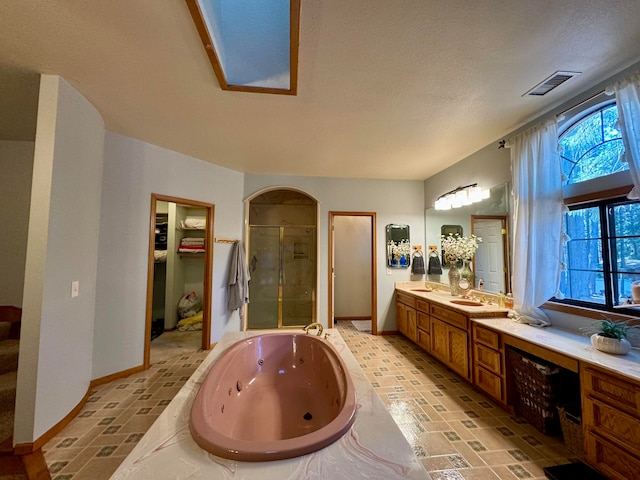 bathroom featuring a textured ceiling, independent shower and bath, and vanity