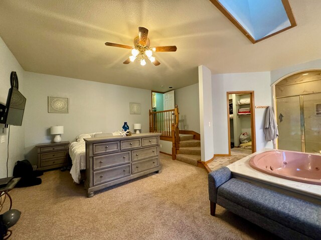 bedroom featuring ceiling fan, a skylight, a textured ceiling, a closet, and light colored carpet