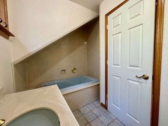 bathroom with vanity, a tub, and tile patterned floors