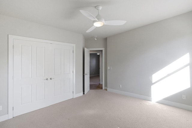 unfurnished bedroom featuring carpet, ceiling fan, and a closet