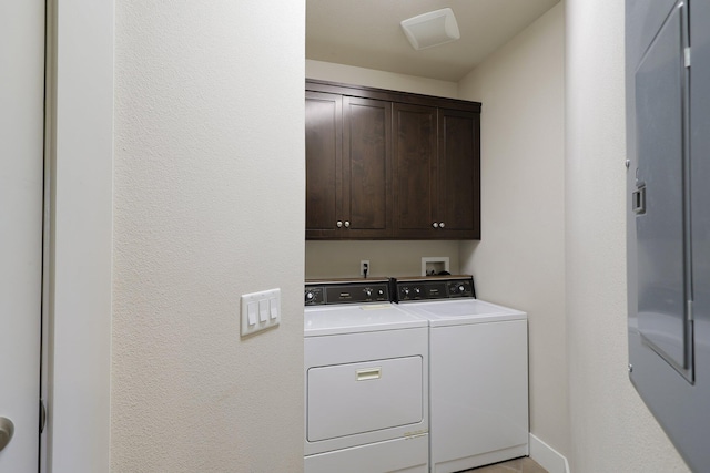 laundry area with separate washer and dryer and cabinets