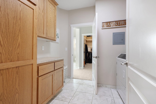 kitchen featuring electric panel, light brown cabinets, and washer / dryer