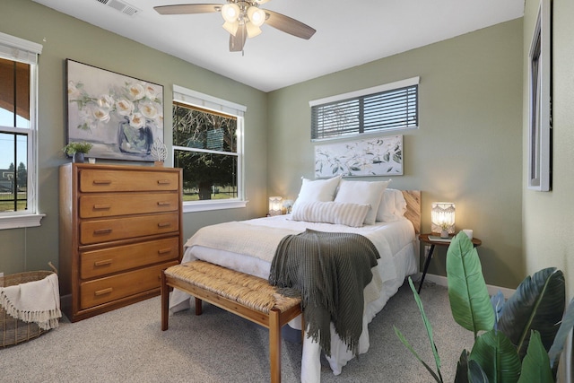 bedroom featuring multiple windows, ceiling fan, and carpet