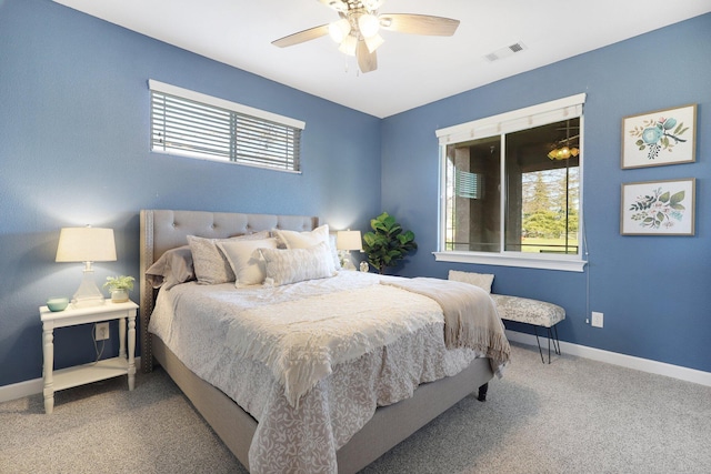 carpeted bedroom with multiple windows and ceiling fan