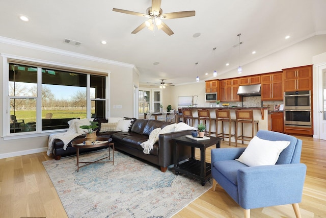 living room featuring ceiling fan, ornamental molding, lofted ceiling, and light wood-type flooring