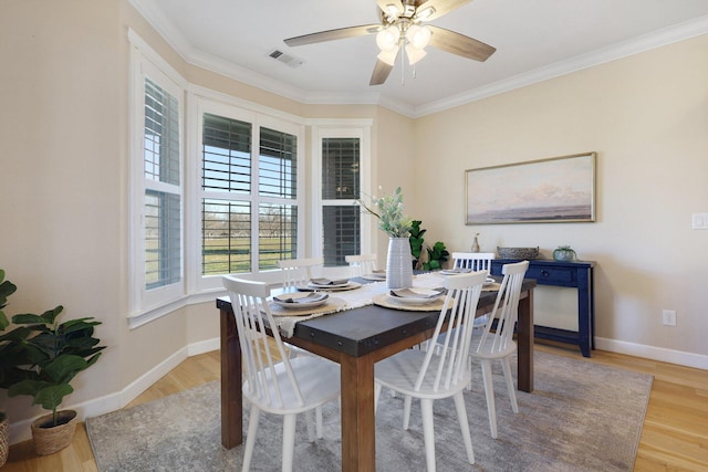 dining space featuring ceiling fan, ornamental molding, and light hardwood / wood-style flooring