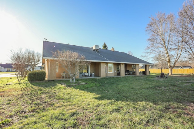 rear view of house with a lawn and a patio area