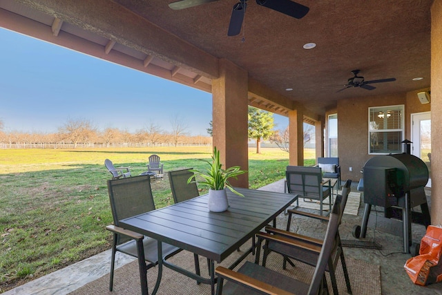 view of patio with ceiling fan and a rural view