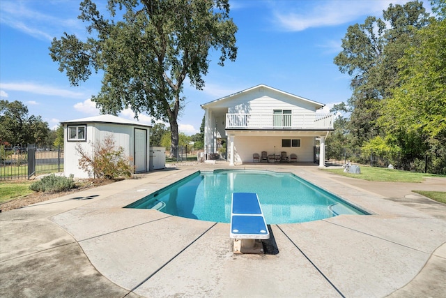 view of swimming pool with a patio and a diving board