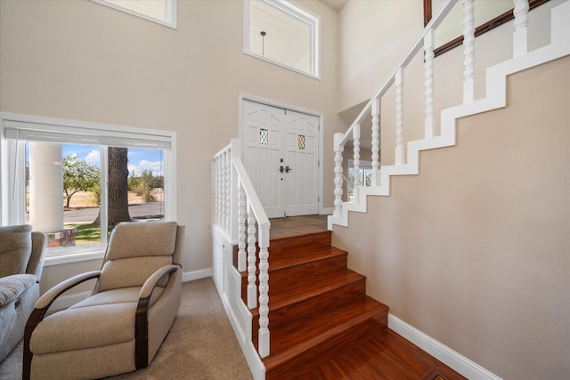 stairway featuring a high ceiling and hardwood / wood-style flooring