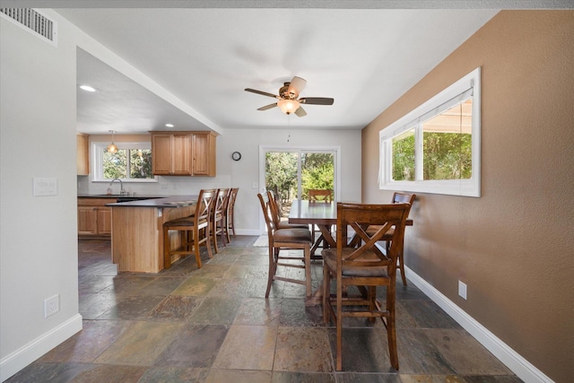 dining space with a wealth of natural light, ceiling fan, and sink