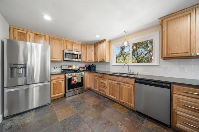 kitchen with decorative light fixtures, appliances with stainless steel finishes, tasteful backsplash, and sink