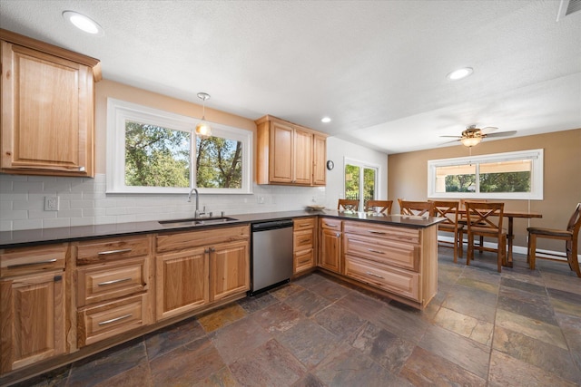 kitchen with hanging light fixtures, kitchen peninsula, dishwasher, ceiling fan, and sink