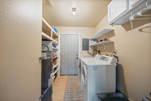 clothes washing area with light tile patterned floors, electric panel, washer and dryer, and cabinets